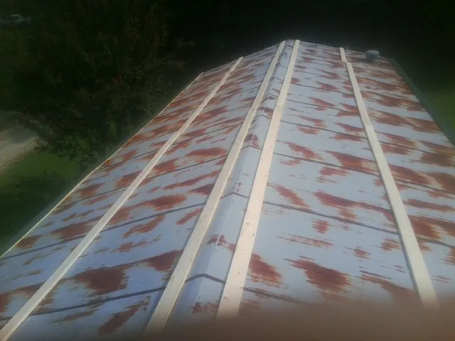 Rusted metal roof panels with new wood purlins before replacement — Storm Damage Roof Repair in Avoca by Roofing Brothers